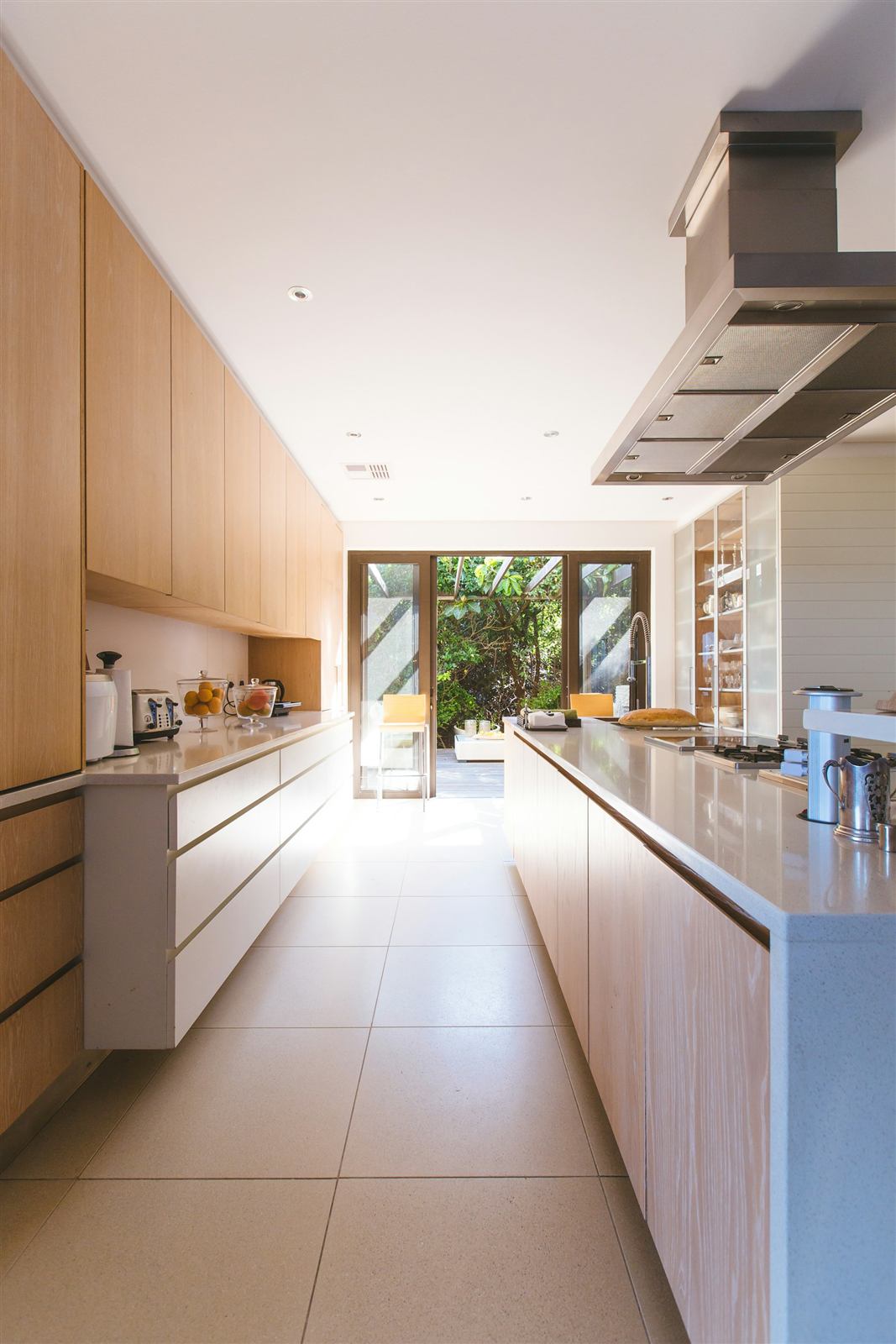 Cuisine blanche et bois avec îlot central et porte vitrée